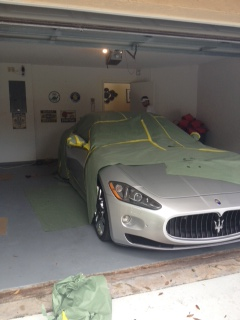 Maserati masked for paint repair in a garage